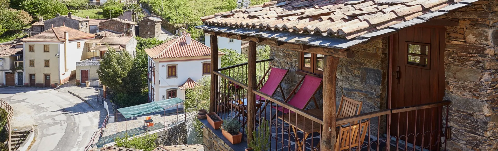 Covered balcony with deckchairs, above the rooftops of the village of Candal