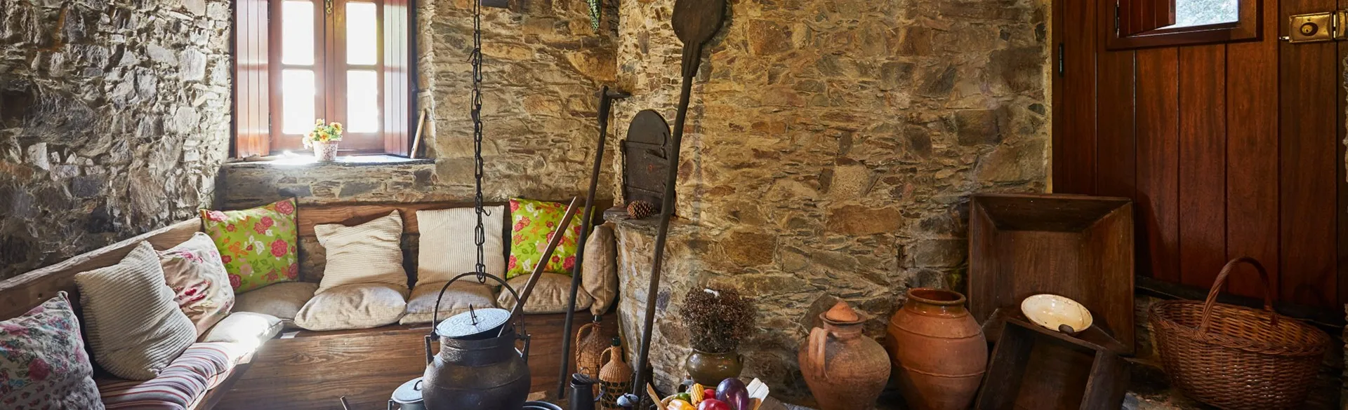 Sitting nook with cushions, earthenware and traditional utensils on the wall