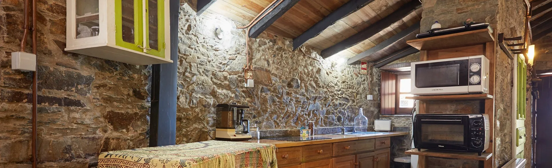 Kitchen equipped with a microwave, an electric oven and a wooden worktop