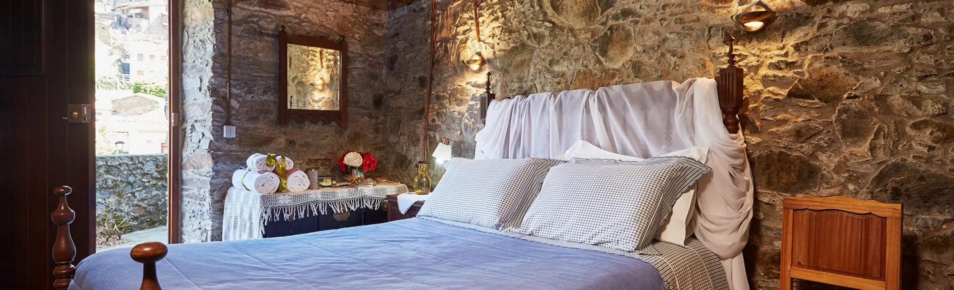 Bedroom with a double bed in white linen and wall lamps