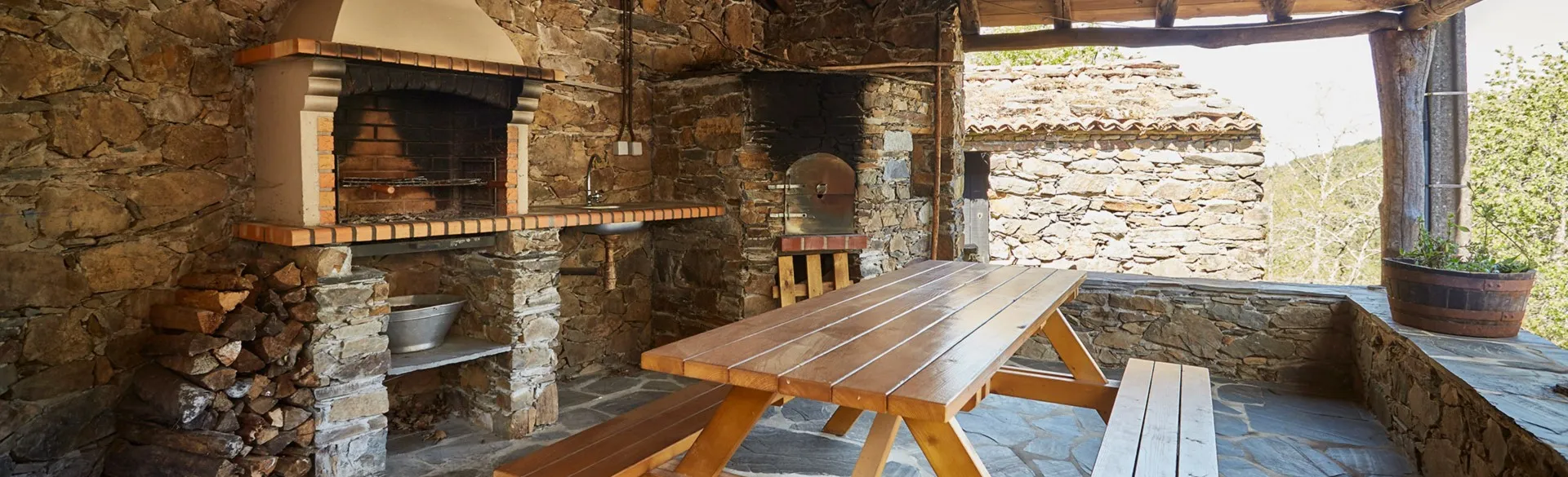 Stone barbecue and picnic table outside the house